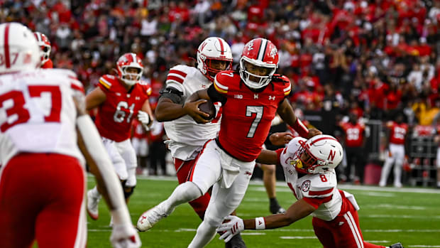 Maryland Terrapins quarterback Malik Washington (7) side steps Nebraska Cornhuskers defensive back DeShon Singleton (8)