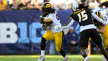 Dec 30, 2024; Nashville, TN, USA;  Iowa Hawkeye running back Jaziun Patterson (9) gets tackled from behind by Missouri Tigers defensive end Johnny Walker Jr. (15) during the first half at Nissan Stadium. Mandatory Credit: Steve Roberts-Imagn Images