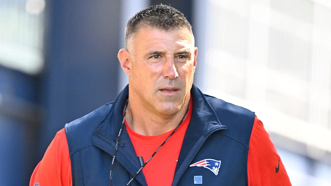 Jul 23, 2025; Foxborough, MA, USA; New England Patriots head coach Mike Vrabel delivers a puppy to a local family as part of the Patriots pet adoption event before the start of training camp at Gillette Stadium. Mandatory Credit: Eric Canha-Imagn Images