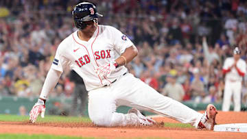 Boston Red Sox third baseman Rafael Devers (11) slides into third base during the fourth inning against the New York Yankees at Fenway Park.