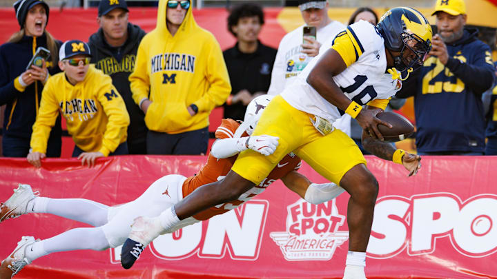 Dec 31, 2025; Orlando, FL, USA; Texas Longhorns defensive back Caleb Chester (25) tackles Michigan Wolverines quarterback Bryce Underwood (19) during the first half at Camping World Stadium. Mandatory Credit: Matt Pendleton-Imagn Images