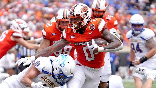 Oklahoma State running back Ollie Gordon III runs by a defender for a score.