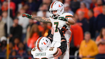 Nov 30, 2024; Syracuse, New York, USA; Miami Hurricanes wide receiver Xavier Restrepo (7) celebrates an offensive play with teammate center Zach Carpenter (50) against the Syracuse Orange during the second half at the JMA Wireless Dome. Mandatory Credit: Rich Barnes-Imagn Images
