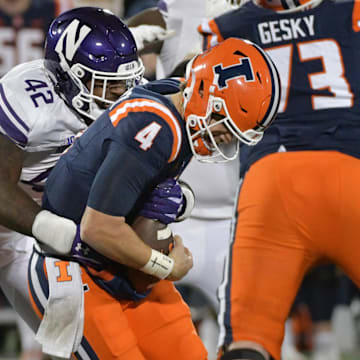 Nov 25, 2023; Champaign, Illinois, USA; Northwestern Wildcats defensive lineman Anto Saka (42) takes down Illinois Fighting Illini quarterback John Paddock (4) during the second half at Memorial Stadium. Mandatory Credit: Ron Johnson-Imagn Images