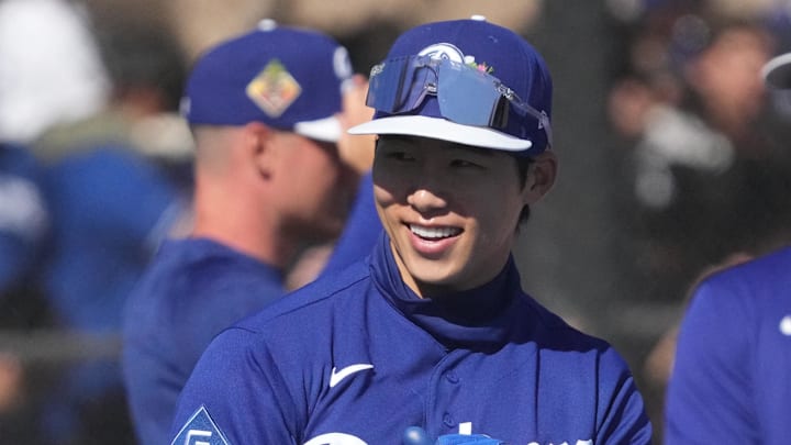 Feb 14, 2026; Glendale, AZ, USA; Los Angeles Dodgers second baseman Hyeseong Kim (6) waves to fan during spring training camp. Mandatory Credit: Rick Scuteri-Imagn Images