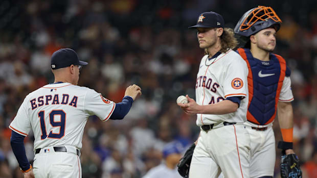 Houston Astros manager Joe Espada take the ball from pitcher Steven Okert wearing a white jersey and blue hat. 