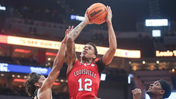 Louisville Cardinals forward JJ Traynor (12) gets fouled by UMBC Retrievers guard Dion Brown (13) Monday night at the Cardinals men's basketball season opener. Nov.6, 2023.