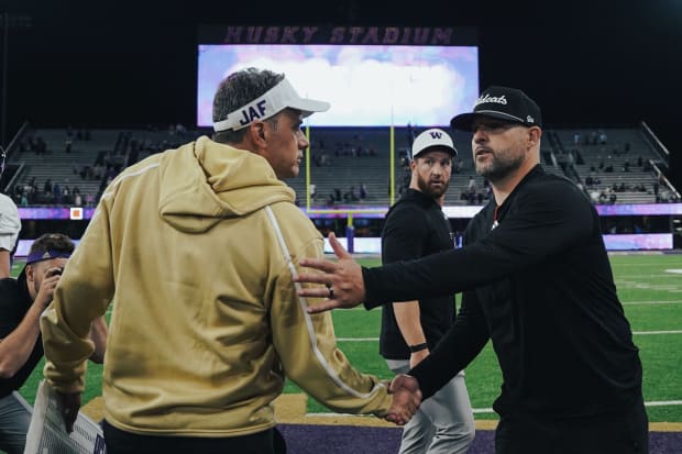 Coaches Jedd Fisch and Mickey Mental share a postgame handshake.