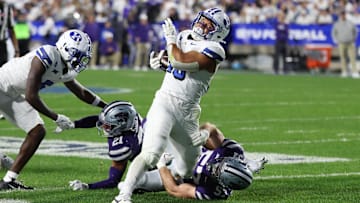 BYU running back Sione Moa fights through defenders to battle to the endzone.