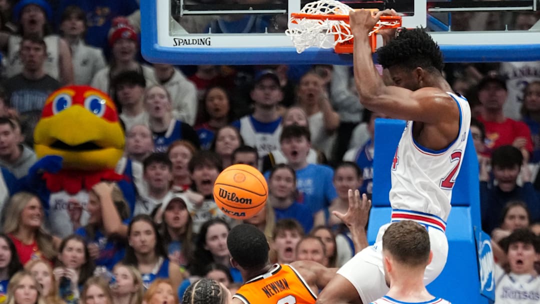Feb 22, 2025; Lawrence, Kansas, USA; Kansas Jayhawks forward KJ Adams Jr. (24) dunks the ball as Oklahoma State Cowboys guard Brandon Newman (6) looks on during the first half at Allen Fieldhouse. Mandatory Credit: Denny Medley-Imagn Images