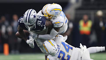 Aug 24, 2024; Arlington, Texas, USA; Dallas Cowboys tight end John Stephens Jr. (81) fumbles the ball after being tackled by Los Angeles Chargers safety Thomas Harper (37) and safety AJ Finley (24) in the second quarter at AT&T Stadium. Mandatory Credit: Tim Heitman-Imagn Images