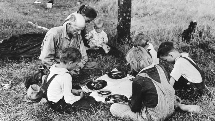 Family having dinner by the road, circa 1930.