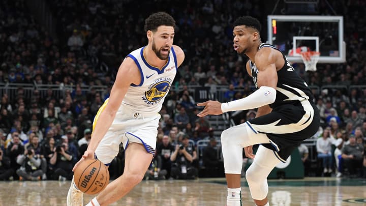 Jan 13, 2024; Milwaukee, Wisconsin, USA; Golden State Warriors guard Klay Thompson (11) drives against Milwaukee Bucks forward Giannis Antetokounmpo (34) in the first half at Fiserv Forum. Mandatory Credit: Michael McLoone-USA TODAY Sports