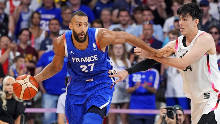 Jul 30, 2024; Villeneuve-d'Ascq, France; France centre Rudy Gobert (27) handles the ball against Japan centre Hugh Watanabe (34) in men’s basketball group B play during the Paris 2024 Olympic Summer Games at Stade Pierre-Mauroy.