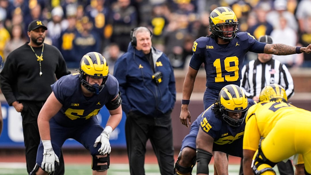 Michigan head coach Sherrone Moore, left, and associate head coach Biff Poggi watch quarterback Bryce Underwood (19)