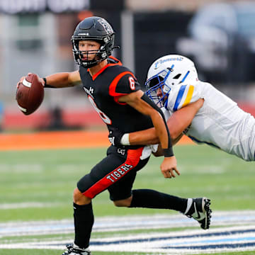 Norman   s Phoenix Murphy (6) is sacked by Stillwater   s Nehemiah Kolone (7) during a high school football game between Stillwater High School and Norman High School in Norman, Okla., on Thursday, Sept. 14, 2023.