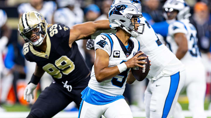 Sep 8, 2024; New Orleans, Louisiana, USA;  Carolina Panthers quarterback Bryce Young (9) scrambles to make a pass as New Orleans Saints defensive end Chase Young (99) rushes at him during the second half at Caesars Superdome. 