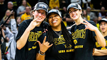 Iowa guards Kate Martin, left, and Caitlin Clark pose for a photo with Iowa assistant coach Raina Harmon after a NCAA Big Ten Conference women's basketball game against Michigan, Sunday, Feb. 27, 2022, at Carver-Hawkeye Arena in Iowa City, Iowa.