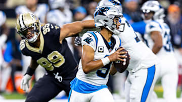 Sep 8, 2024; New Orleans, Louisiana, USA;  Carolina Panthers quarterback Bryce Young (9) scrambles to make a pass as New Orleans Saints defensive end Chase Young (99) rushes at him during the second half at Caesars Superdome. Mandatory Credit: Stephen Lew-Imagn Images