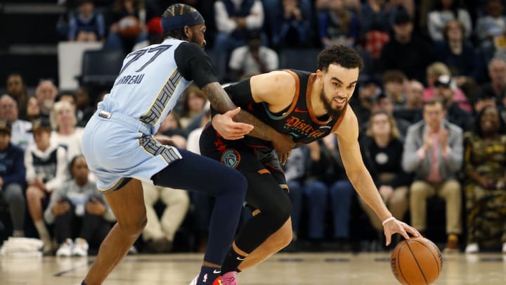 Mar 12, 2024; Memphis, Tennessee, USA; Washington Wizards guard Tyus Jones (5) dribbles the ball up the court as Memphis Grizzlies guard Dejon Jarreau (77) defends during the first half at FedExForum. Mandatory Credit: Petre Thomas-USA TODAY Sports