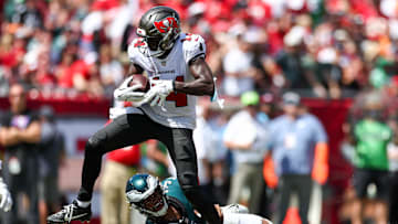 Sep 29, 2024; Tampa, Florida, USA; Tampa Bay Buccaneers wide receiver Chris Godwin (14) stretches past Philadelphia Eagles linebacker Nolan Smith Jr. (3) for extra yards in the second quarter at Raymond James Stadium. Mandatory Credit: Nathan Ray Seebeck-Imagn Images