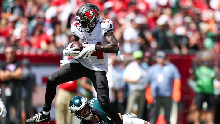 Sep 29, 2024; Tampa, Florida, USA; Tampa Bay Buccaneers wide receiver Chris Godwin (14) stretches past Philadelphia Eagles linebacker Nolan Smith Jr. (3) for extra yards in the second quarter at Raymond James Stadium. Mandatory Credit: Nathan Ray Seebeck-Imagn Images