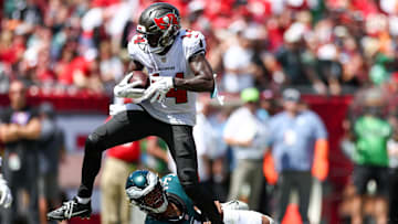 Sep 29, 2024; Tampa, Florida, USA; Tampa Bay Buccaneers wide receiver Chris Godwin (14) stretches past Philadelphia Eagles linebacker Nolan Smith Jr. (3) for extra yards in the second quarter at Raymond James Stadium. Mandatory Credit: Nathan Ray Seebeck-Imagn Images