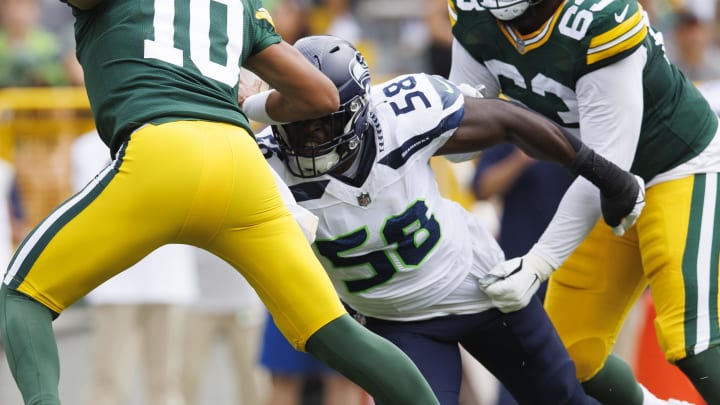 Aug 26, 2023; Green Bay, Wisconsin, USA;  Green Bay Packers quarterback Jordan Love (10) escapes pressure from Seattle Seahawks outside linebacker Derick Hall (58) during the first quarter at Lambeau Field.