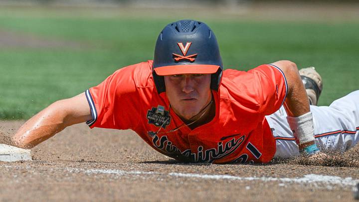 Jun 14, 2024; Omaha, NE, USA;  Virginia Cavaliers third baseman Eric Becker (21) slides back into first base against the North Carolina Tar Heels during the 2024 CWS. Mandatory Credit: Steven Branscombe-Imagn Images