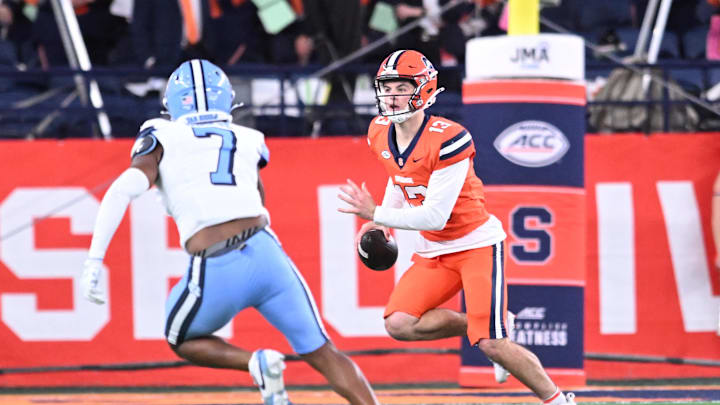 Oct 31, 2025; Syracuse, New York, USA; Syracuse Orange quarterback Joseph Filardi (13) runs from North Carolina Tar Heels linebacker Khmori House (7) in the second quarter at the JMA Wireless Dome. Mandatory Credit: Mark Konezny-Imagn Images