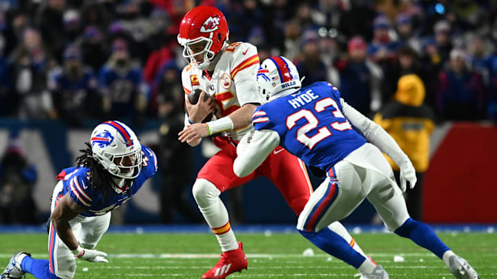 Jan 21, 2024; Orchard Park, New York, USA; Kansas City Chiefs quarterback Patrick Mahomes (15) rushes the ball past Buffalo Bills safety Micah Hyde (23) in the second half of the 2024 AFC divisional round game at Highmark Stadium.