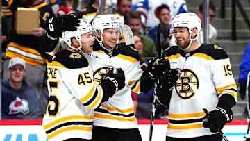 Oct 16, 2024; Denver, Colorado, USA; Boston Bruins left wing Cole Koepke (45) celebrates his goal with defenseman Andrew Peeke (52) and center John Beecher (19) in the first period against the Colorado Avalanche at Ball Arena. Mandatory Credit: Ron Chenoy-Imagn Images