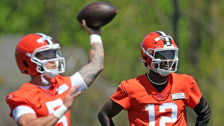 Cleveland Browns quarterback Shedeur Sanders (12) watches as quarterback Dillon Gabriel (5) throws during NFL rookie minicamp at the Cleveland Browns training facility on Friday, May 9, 2025, in Berea, Ohio.