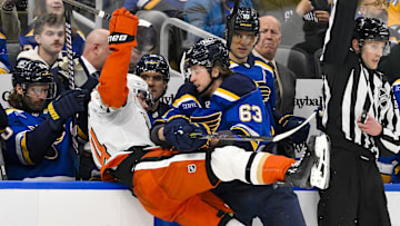 Jan 9, 2025; St. Louis, Missouri, USA;  St. Louis Blues left wing Jake Neighbours (63) checks Anaheim Ducks defenseman Pavel Mintyukov (34) during the second period at Enterprise Center. Mandatory Credit: Jeff Curry-Imagn Images