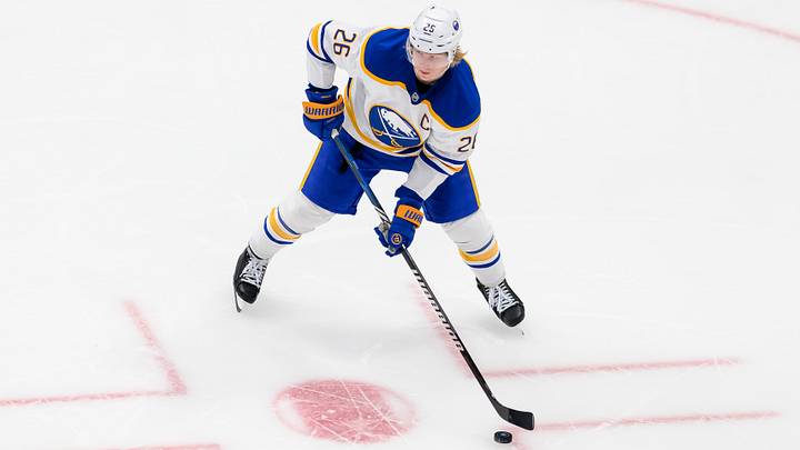 Rasmus Dahlin (26) looking to make a quick pass in a game against the Utah Hockey Club. 