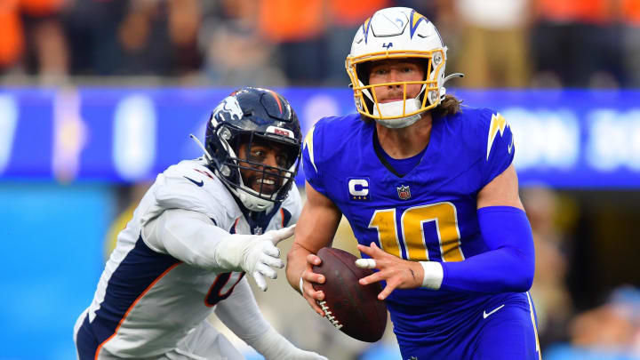 Dec 10, 2023; Inglewood, California, USA; Los Angeles Chargers quarterback Justin Herbert (10) moves out to pass against the defense of Denver Broncos linebacker Jonathon Cooper (0) during the first half at SoFi Stadium. Mandatory Credit: Gary A. Vasquez-USA TODAY Sports