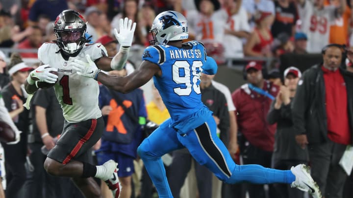 Dec 3, 2023; Tampa, Florida, USA; Tampa Bay Buccaneers running back Rachaad White (1) stiff arms Carolina Panthers linebacker Marquis Haynes Sr. (98)  during the second half at Raymond James Stadium. Mandatory Credit: Kim Klement Neitzel-USA TODAY Sports