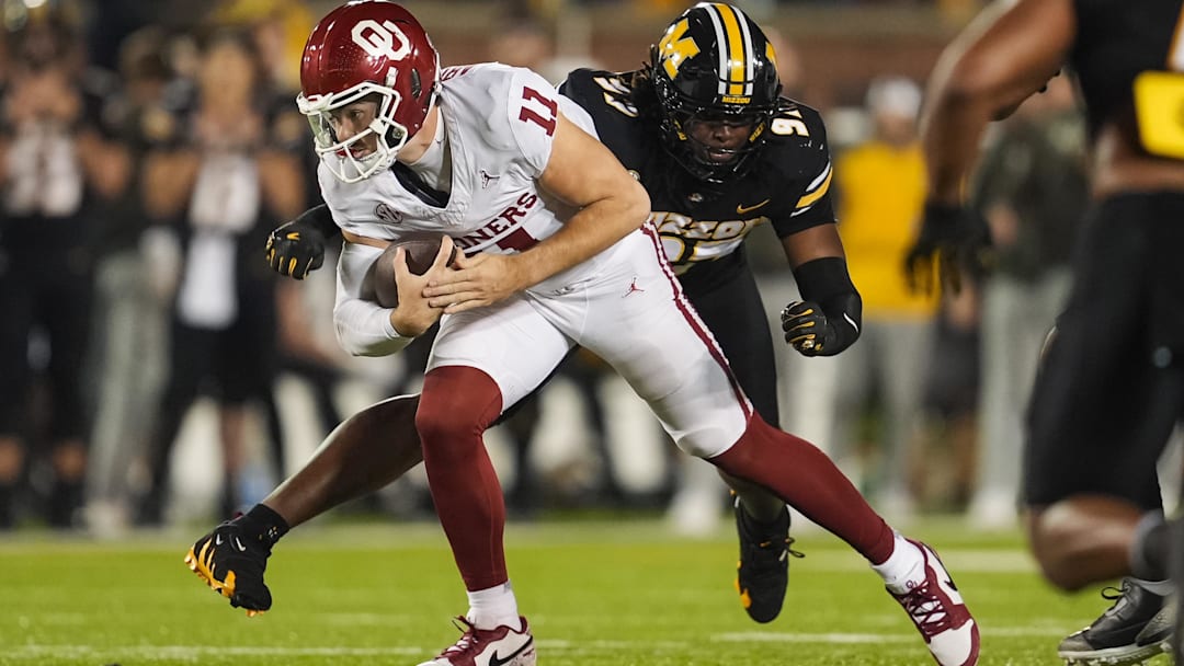 Nov 9, 2024; Columbia, Missouri, USA; Oklahoma Sooners quarterback Jackson Arnold (11) runs the ball against Missouri Tigers defensive end Eddie Kelly Jr. (97) during the first half at Faurot Field at Memorial Stadium. Mandatory Credit: Jay Biggerstaff-Imagn Images