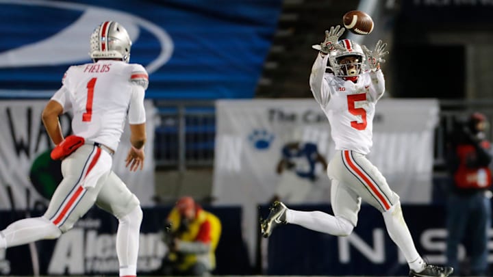Fields throws a pass to Wilson during a 2020 game with Ohio State. 