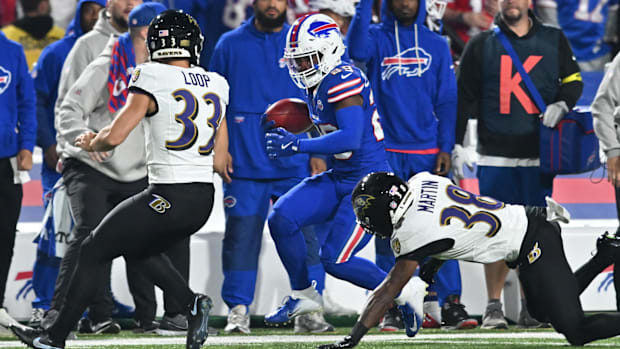 Buffalo Bills cornerback Brandon Codrington runs the ball against Baltimore Ravens corner Keyon Martin and kicker Tyler Loop.