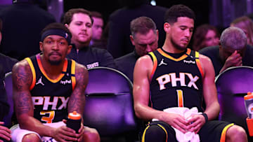 Apr 9, 2025; Phoenix, Arizona, USA; Phoenix Suns guard Bradley Beal (3) and guard Devin Booker (1) react on the bench against the Oklahoma City Thunder during the second half at Footprint Center. Mandatory Credit: Mark J. Rebilas-Imagn Images