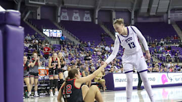 Sedona Prince helping a Utah Basketball player up, 1/14/2024