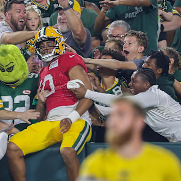 Green Bay Packers quarterback Jordan Love (10) does a Lambeau Leap after finishing a drill during Family Night on Saturday.