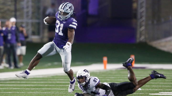 Oct 21, 2023; Manhattan, Kansas, USA; Kansas State Wildcats running back DJ Giddens (31) runs by TCU Horned Frogs safety Bud Clark (21) during the fourth quarter at Bill Snyder Family Football Stadium. Mandatory Credit: Scott Sewell-USA TODAY Sports