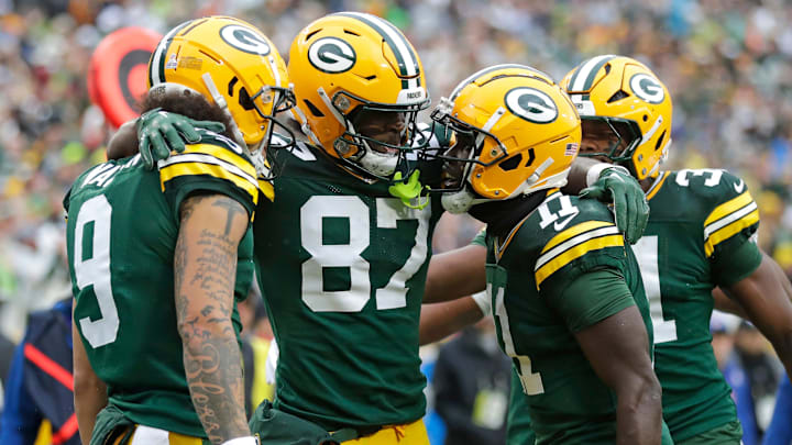 Green Bay Packers wide receiver Romeo Doubs (87) celebrates scoring a touchdown with wide receiver Christian Watson (9), wide receiver Jayden Reed (11) and running back Emanuel Wilson (31) against the Arizona Cardinals during their football game Sunday, October 13, 2024, at Lambeau Field in Green Bay, Wisconsin.