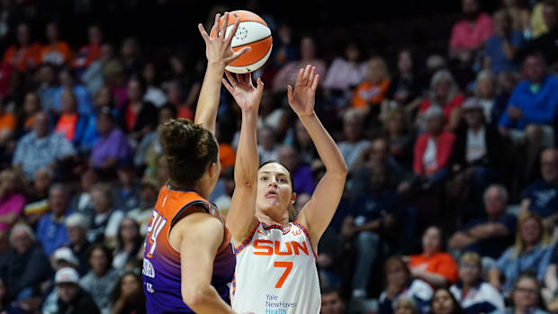 Connecticut Sun forward Haley Peters shoots while wearing a white uniform.