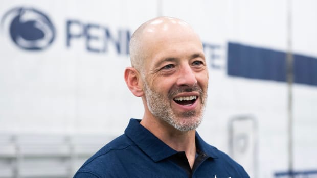 Penn State special teams coordinator Justin Lustig smiles as he answers a reporter's question in an interview.