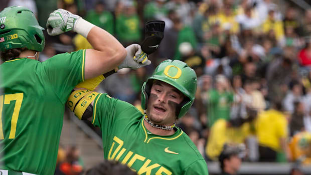 Oregon outfielder Mason Neville, right, celebrates a home run with teammate Drew Smith