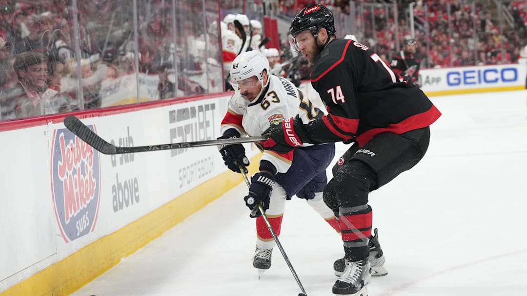 May 20, 2025; Raleigh, North Carolina, USA; Carolina Hurricanes defenseman Jaccob Slavin (74) defends against Florida Panthers forward Brad Marchand (63) during the second period in game one of the Eastern Conference Final of the 2025 Stanley Cup Playoffs at Lenovo Center. Mandatory Credit: James Guillory-Imagn Images May 20, 2025; Raleigh, North Carolina, USA; Carolina Hurricanes defenseman Jaccob Slavin (74) defends against Florida Panthers forward Brad Marchand (63) during the second period in game one of the Eastern Conference Final of the 2025 Stanley Cup Playoffs at Lenovo Center. Mandatory Credit: James Guillory-Imagn Images