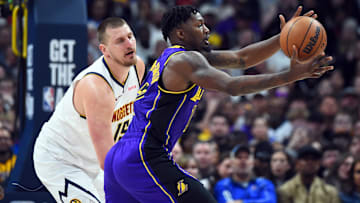 Feb 22, 2025; Denver, Colorado, USA; Los Angeles Lakers forward Dorian Finney-Smith (17) reaches for a loose ball as he is defended by Denver Nuggets center Nikola Jokic (15) during the second half at Ball Arena. Mandatory Credit: Christopher Hanewinckel-Imagn Images
